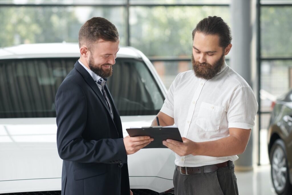 Advisor and buyer reviewing used car details on a tablet before purchase
