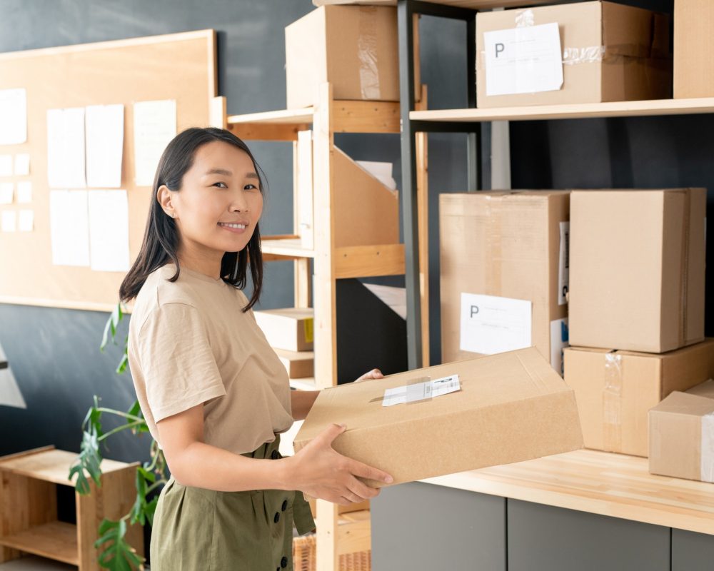 smiling-youngworker-of-post-office-or-storage-room-carrying-order-of-client.jpg